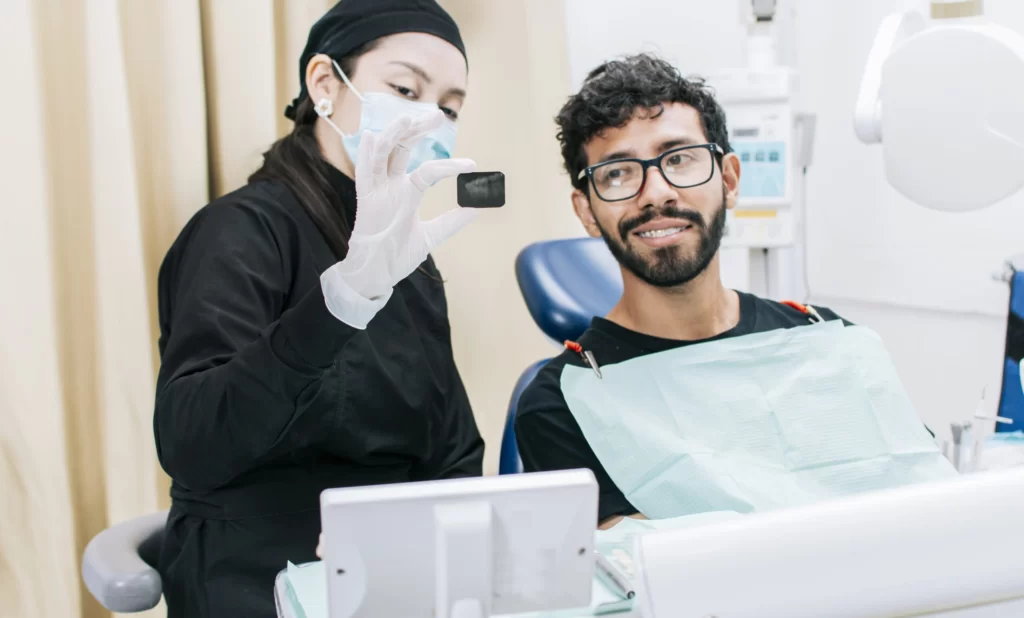 Dental Imaging 1 dentist with patient showing him periapical xray view dentist with patient reviewing dental xray dentist showing periapical xray patient 1 scaled 1
